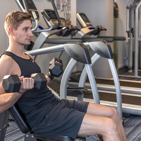 Meriton Suites North Ryde Sidney Exterior foto A man using a dumbbell to exercise