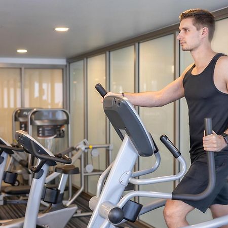 Meriton Suites North Ryde Sidney Exterior foto A man using an elliptical trainer