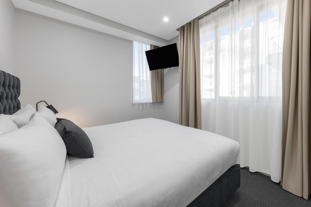 Meriton Suites North Ryde Sidney Exterior foto A bedroom at the hotel