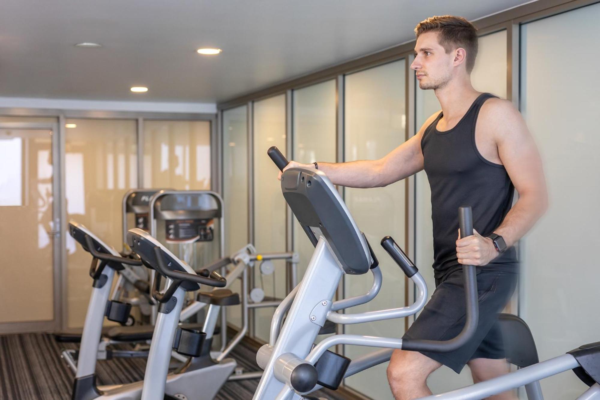 Meriton Suites North Ryde Sidney Exterior foto A man using an elliptical trainer
